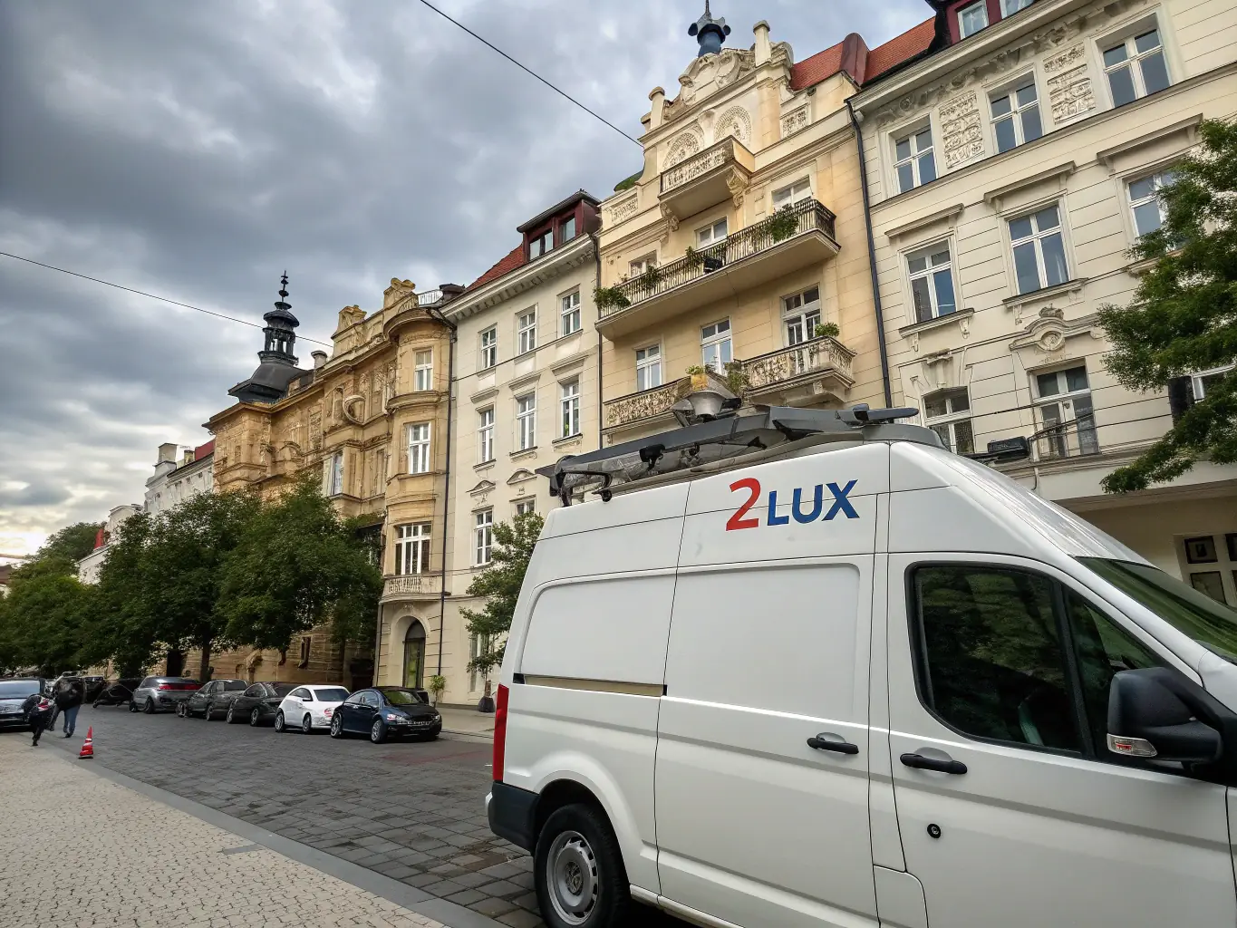 Zdjęcie vana z dużym bagażem na tle warszawskiej ulicy, z widocznymi charakterystycznymi budynkami.